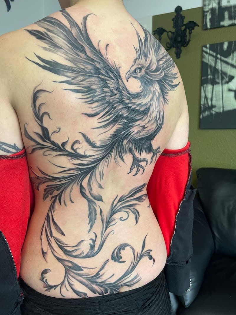 Grote zwart-wit feniks tattoo over de hele rug met sierlijke staart.