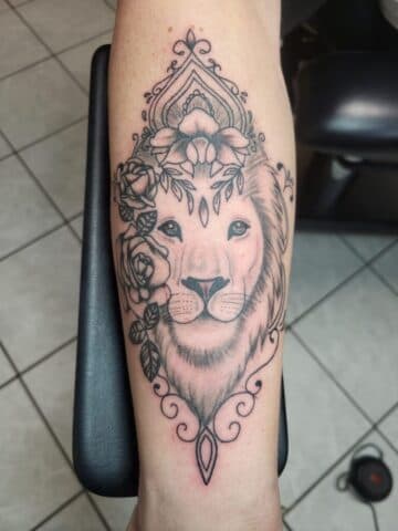 Fineline leeuwenkop met rozen en sierlijke omlijsting.