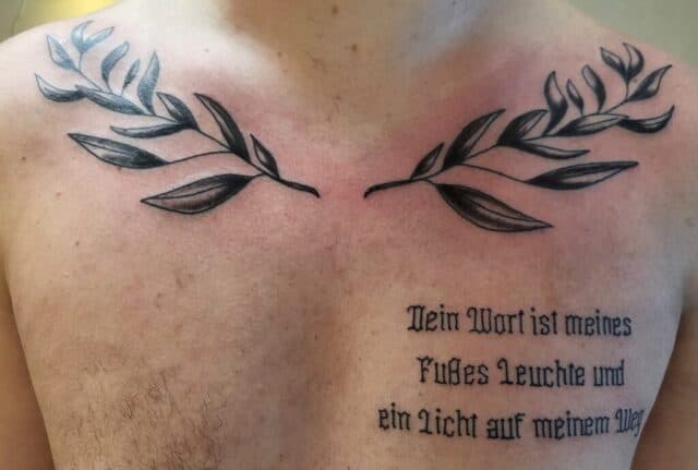 Twee olijftakken en Duitse bijbeltekst op de borst.