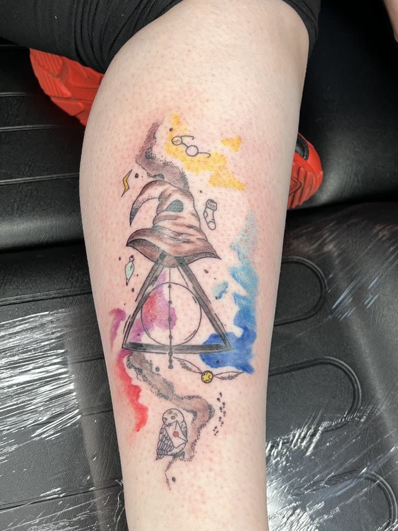 Harry Potter tattoo met Sorteerhoed, Relieken en waterverf op onderbeen.