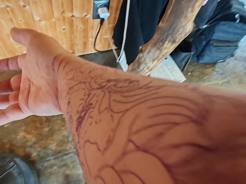Onvoltooide lijntekening tattoo op onderarm.