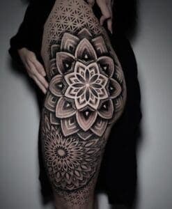 Grote geometrische mandala tattoo op bovenbeen en heup, dotwork stijl.