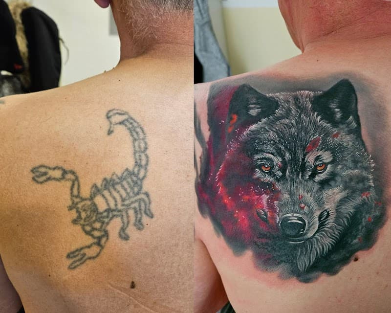 Realistische wolf cover-up tattoo op schouderblad.