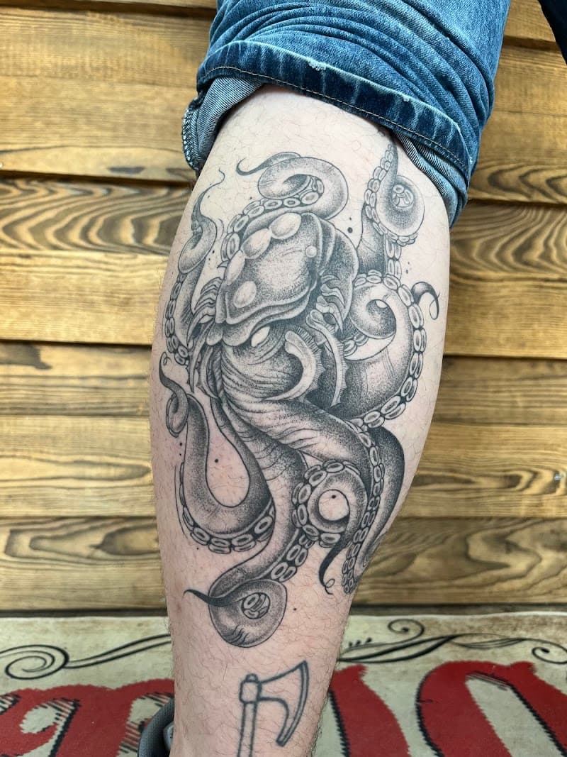 Gedetailleerde zwart-wit octopus tattoo op het onderbeen.