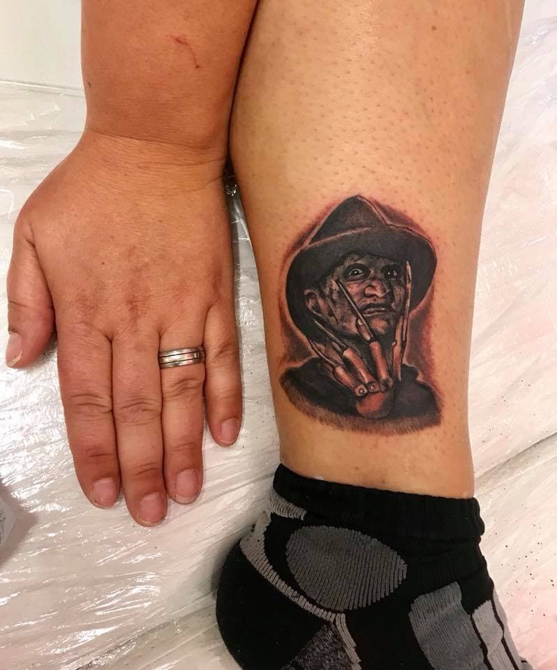 Realistisch portret van Freddy Krueger op het onderbeen.