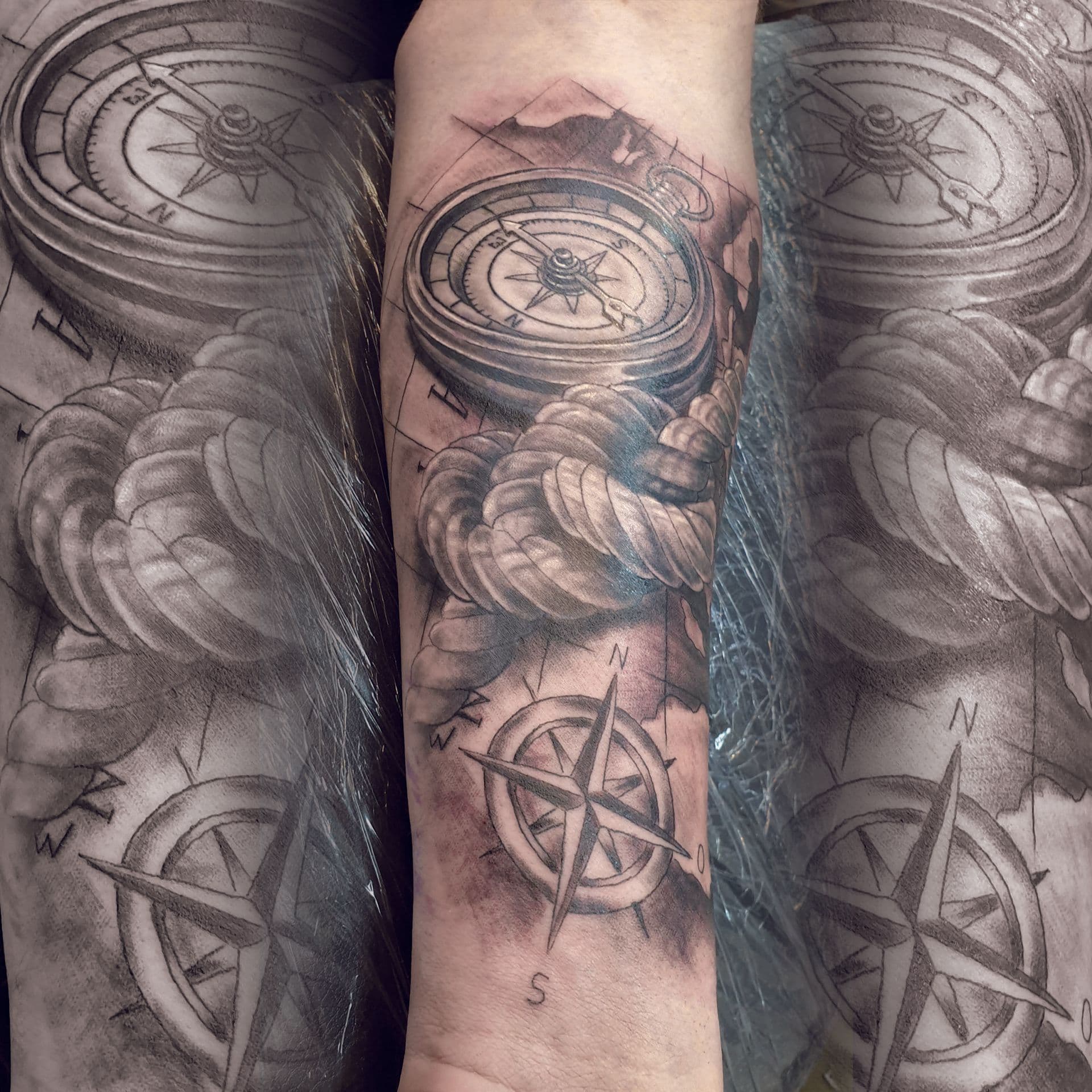 Zwart-wit kompas, touw en landkaart op onderarm.