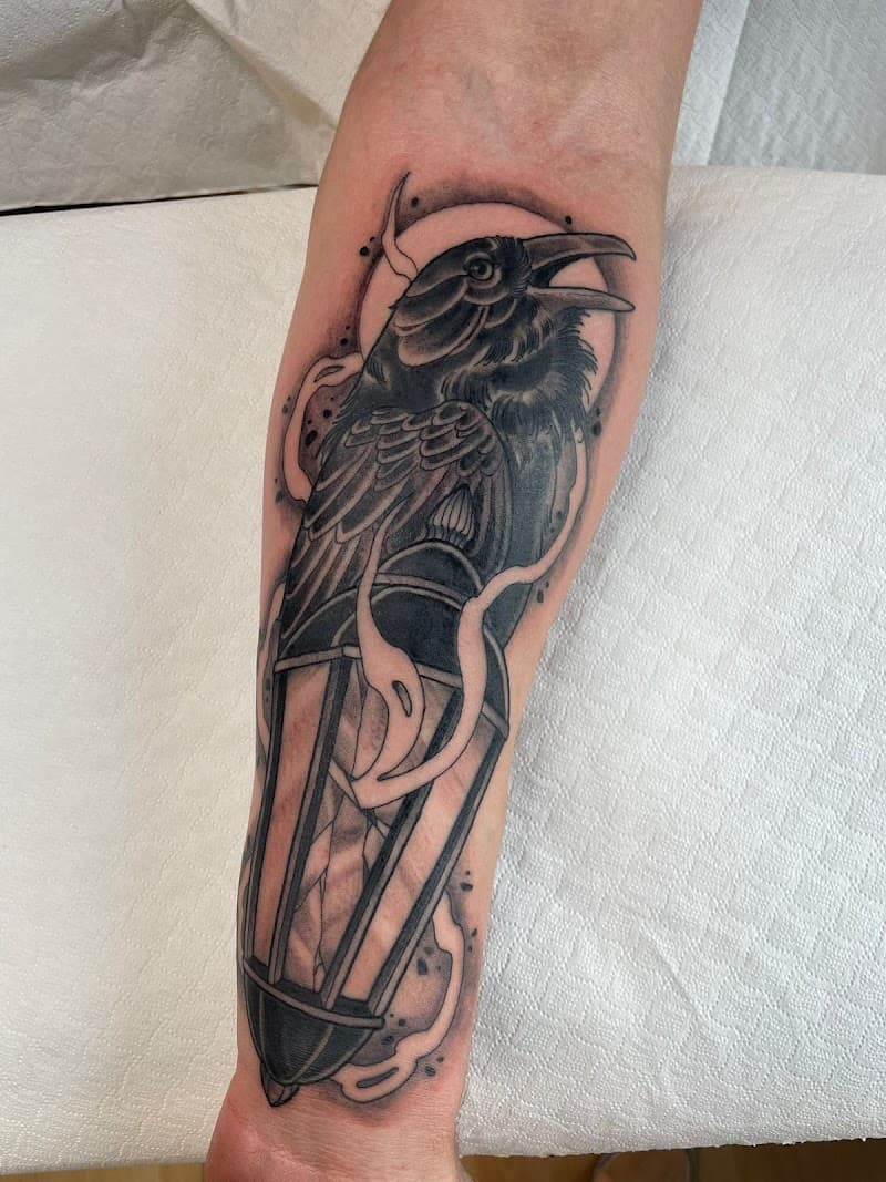 Blackwork tattoo van een raaf op een lantaarn met rook.
