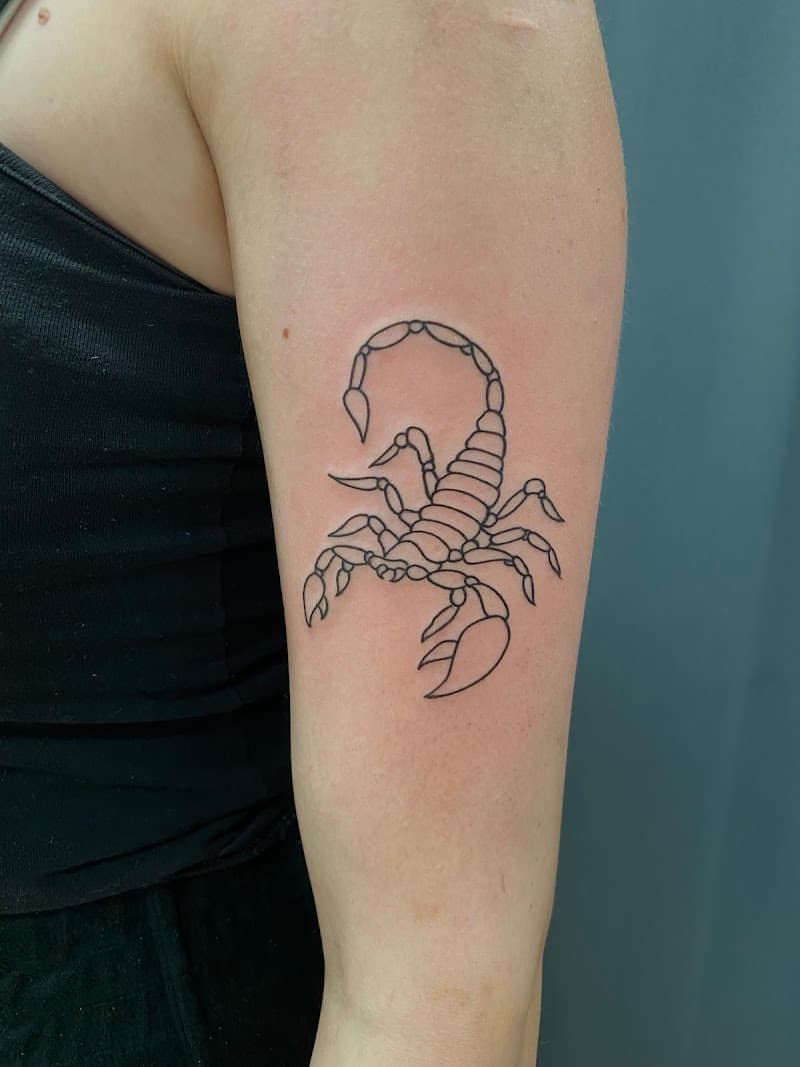 Fineline schorpioen tattoo op de bovenarm.