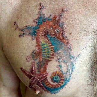 Kleurrijke zeepaard en zeester tattoo met water splash.