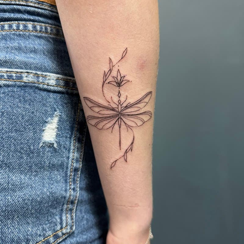 Fineline libelle met bloem en bladeren op onderarm.