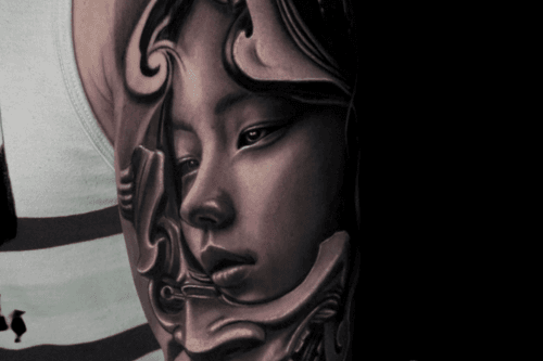 Realistisch portret van een vrouw in een sierlijke omlijsting op de bovenarm.