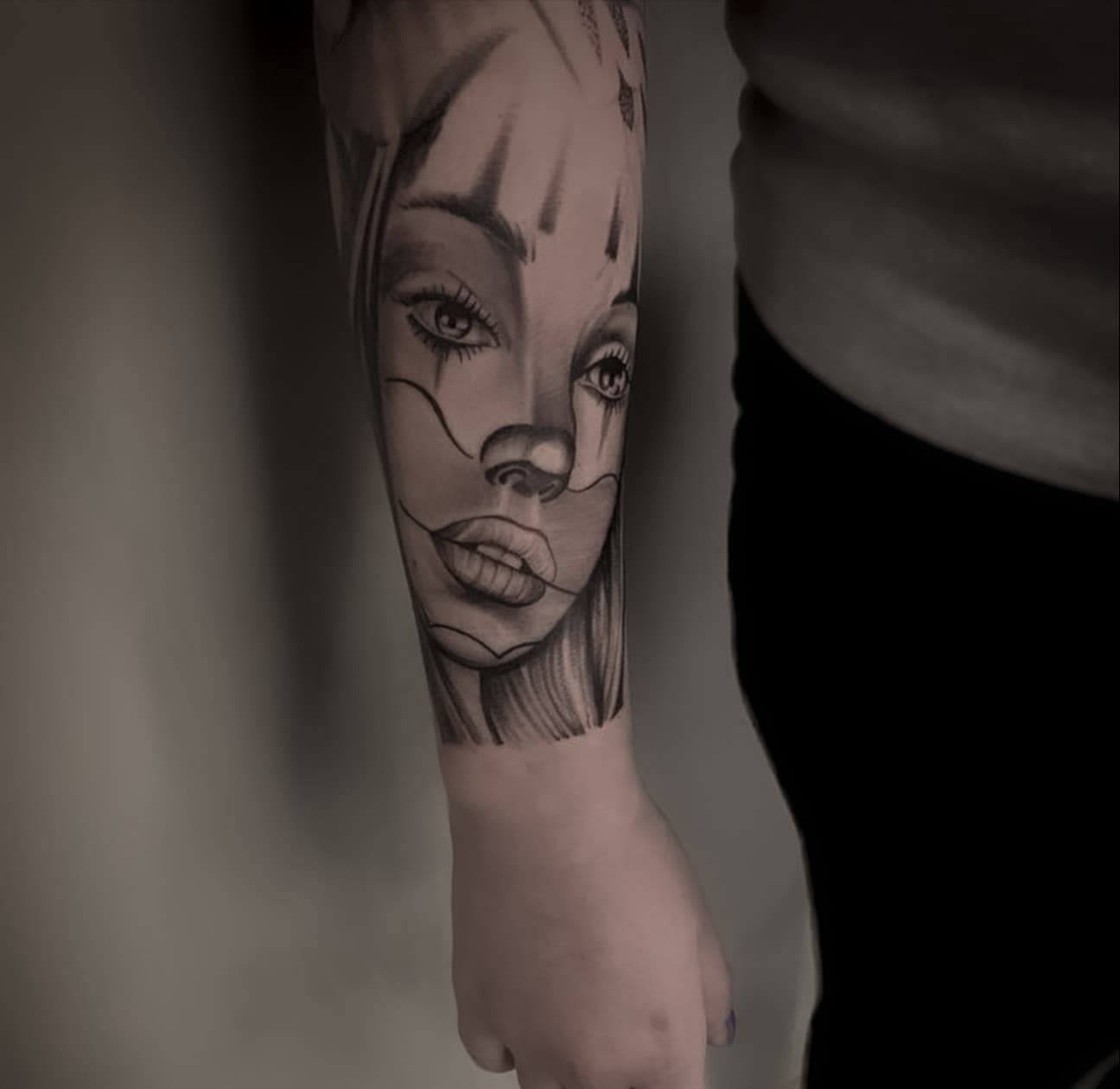 Zwart-wit portret van vrouw met Chicano clownsmake-up op onderarm.