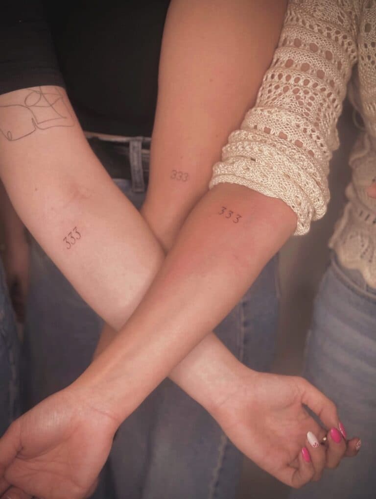 Drie kleine '333' nummer tattoos op onderarmen