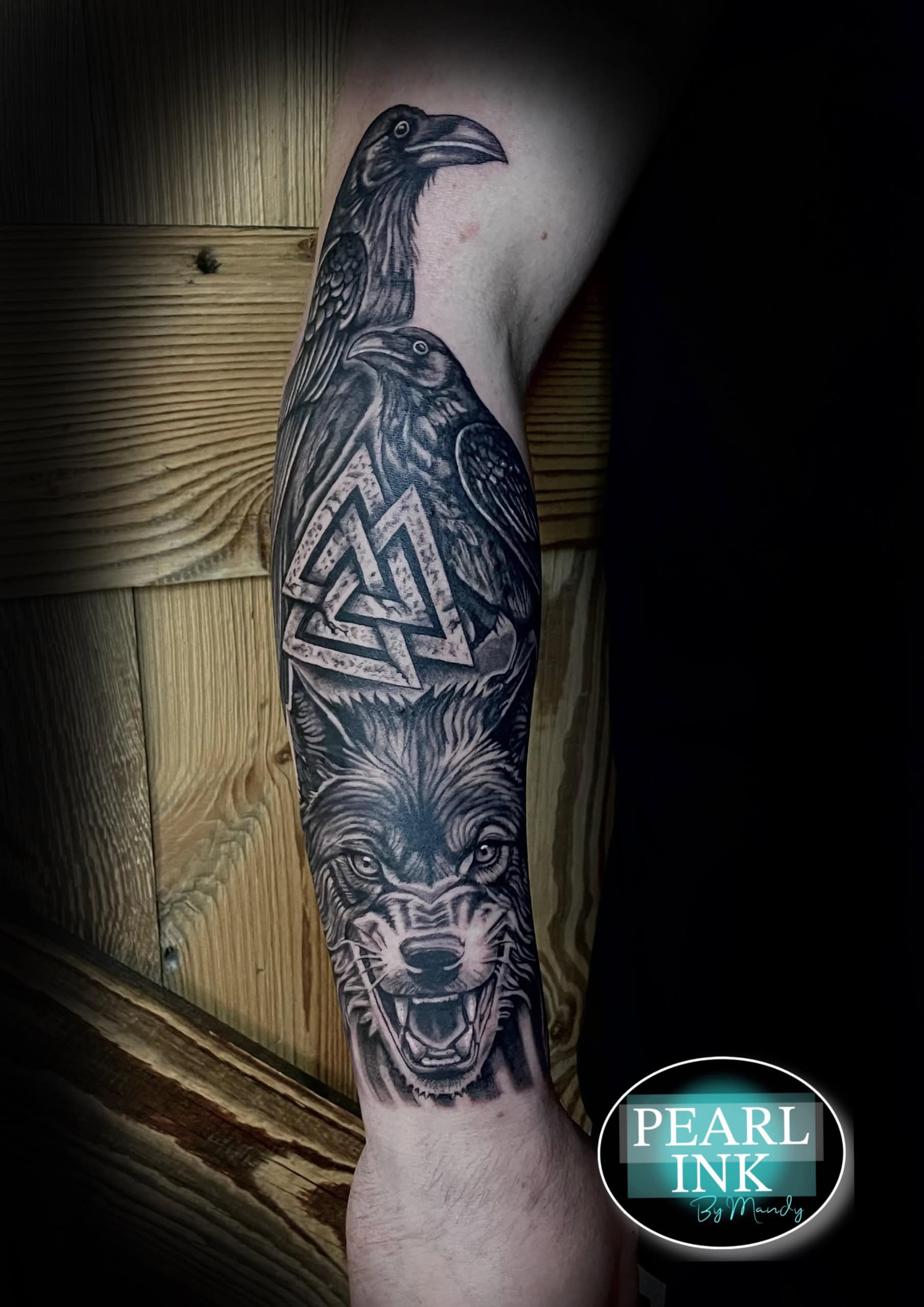 Realistische wolf, twee raven en Valknut symbool op onderarm.