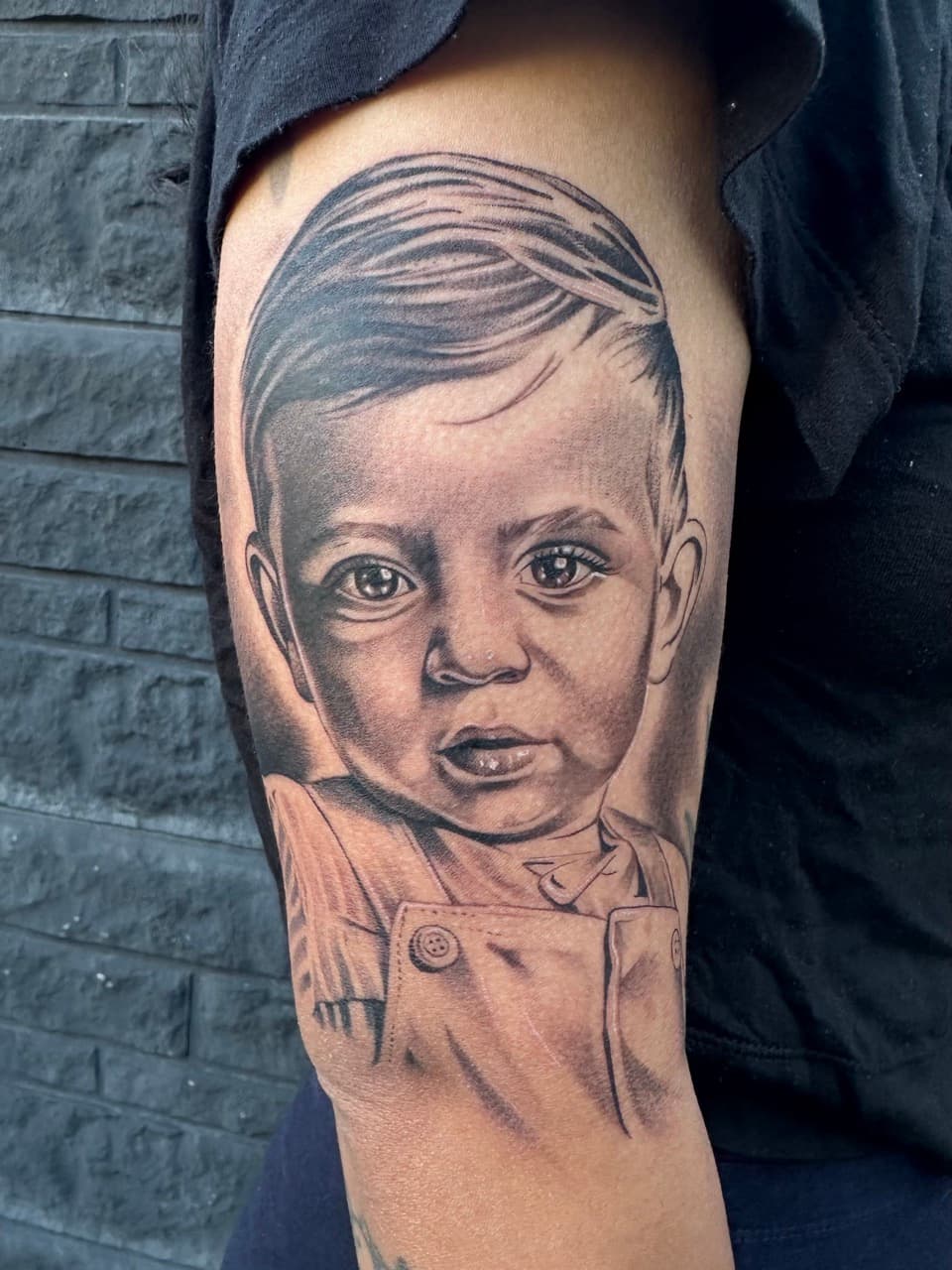 Realistisch portret van een jongetje op de bovenarm.