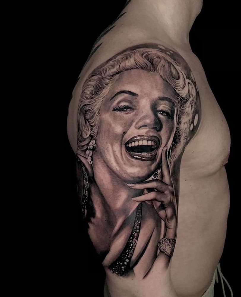 Realistisch portret van lachende Marilyn Monroe op bovenarm.