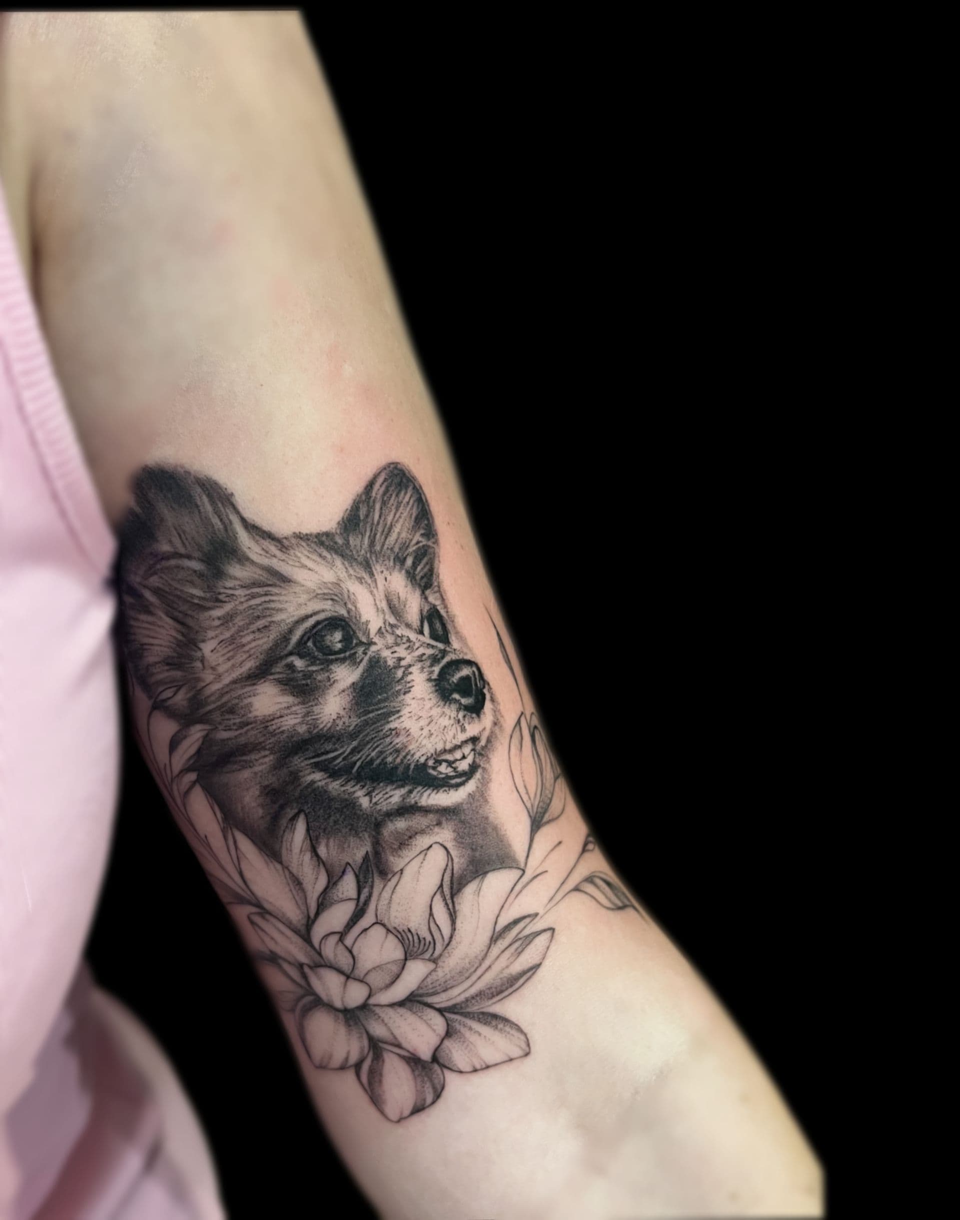 Realistisch portret van een hond met bloemen op de bovenarm.