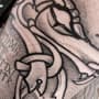 Viking draak en runen in blackwork stijl op de arm.