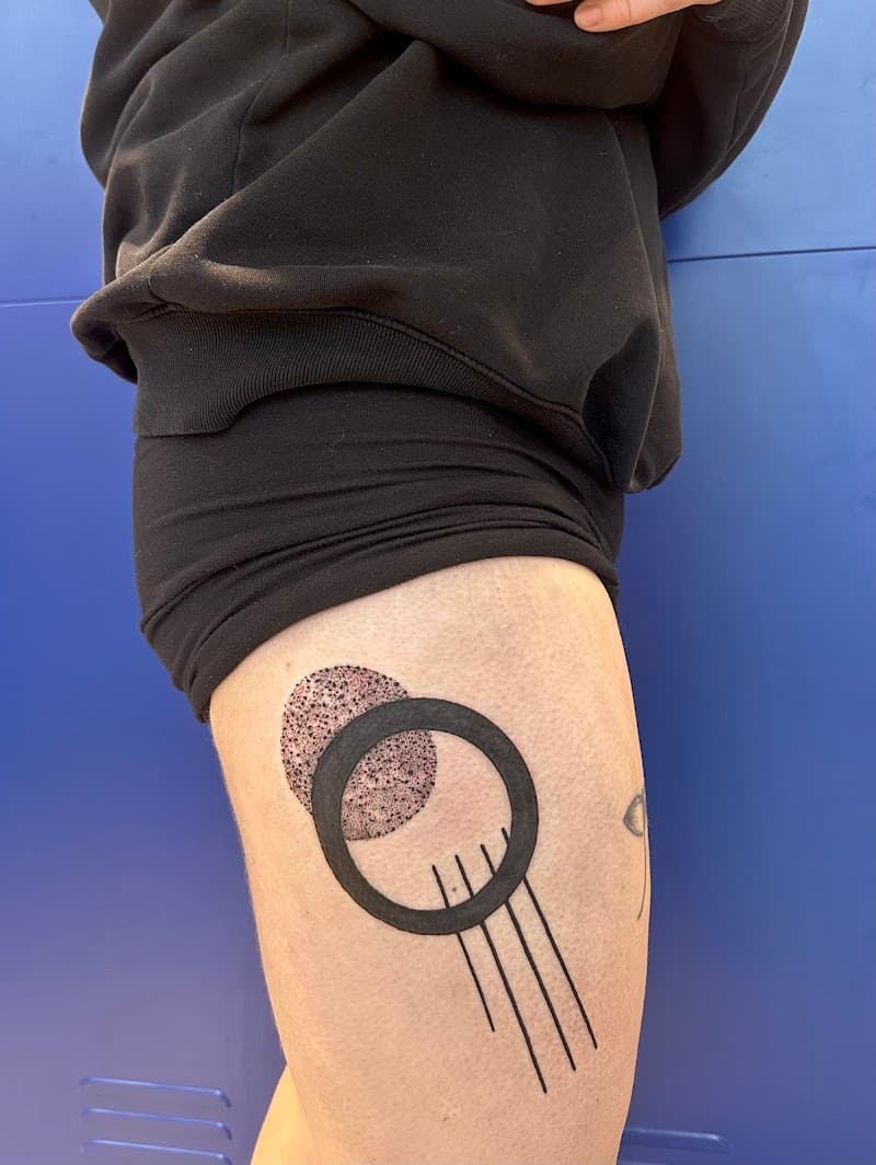 Geometrische tattoo met cirkels en lijnen op bovenbeen.