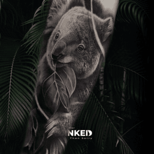 Realistische zwart-wit tattoo van een koala met een blad op de bovenarm.