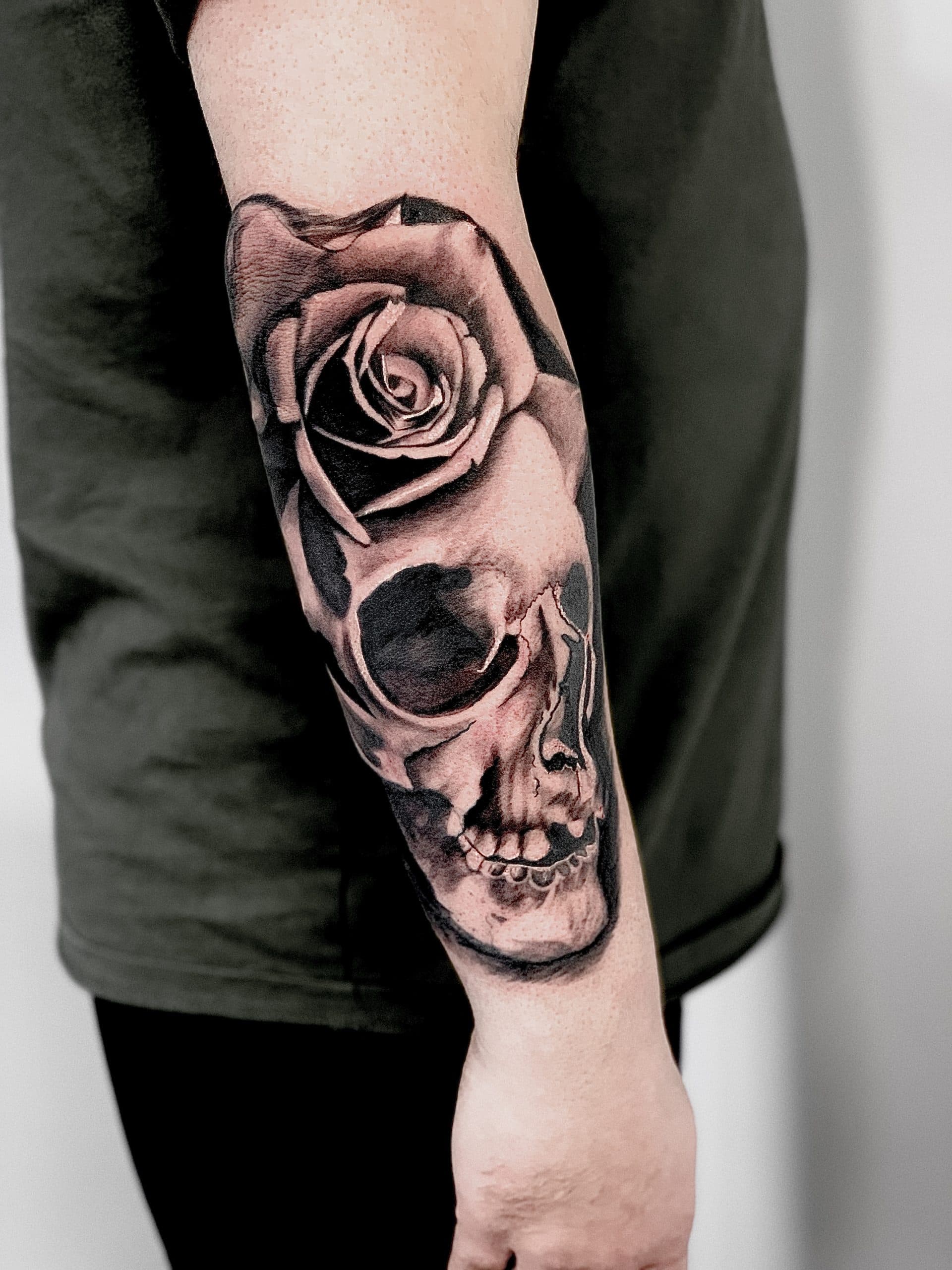 Realistische schedel met een roos op de onderarm.