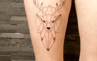 Geometrisch hert tattoo op bovenbeen.