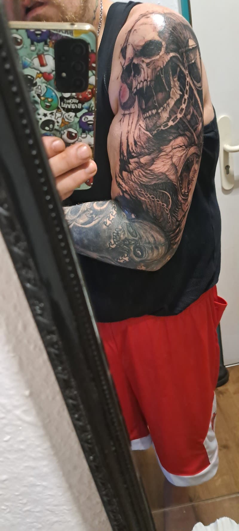 Realistische schedel met kettingen en monster op bovenarm.