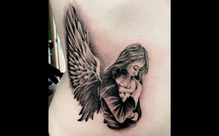 Realistische tattoo van een engel die een baby vasthoudt op de ribben.