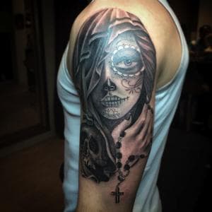 Realistische zwart-wit tattoo van een vrouw met suikerschedel make-up en rozenkrans.