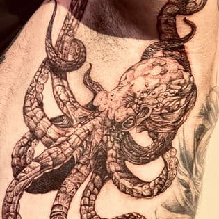 Gedetailleerde zwart-wit inktvis tattoo op de schouder.