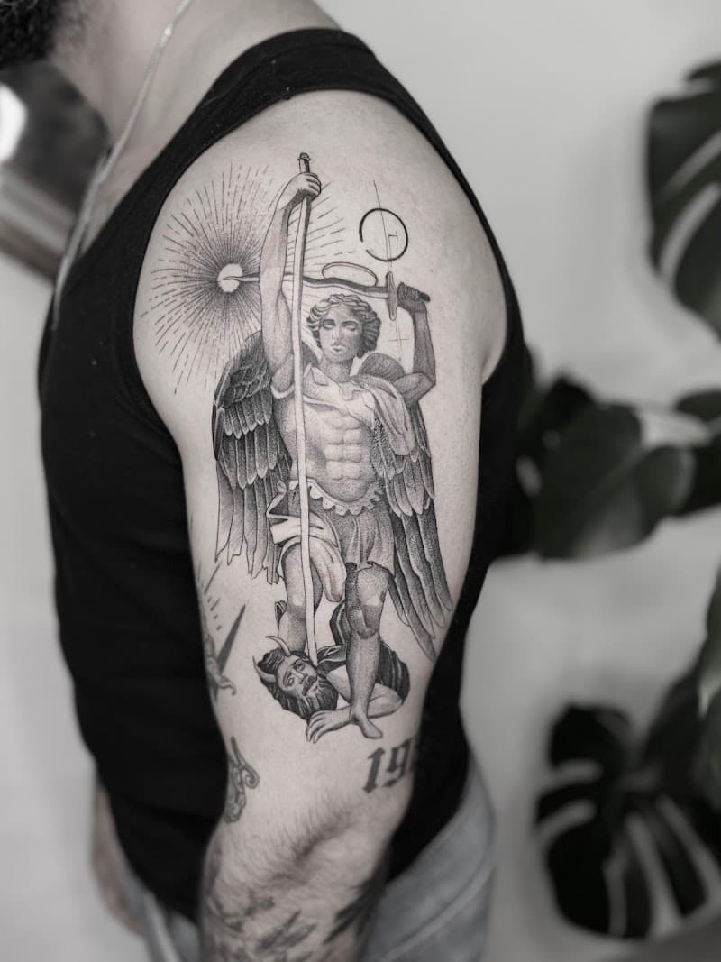 Gedetailleerde aartsengel Michaël die de duivel verslaat op bovenarm.