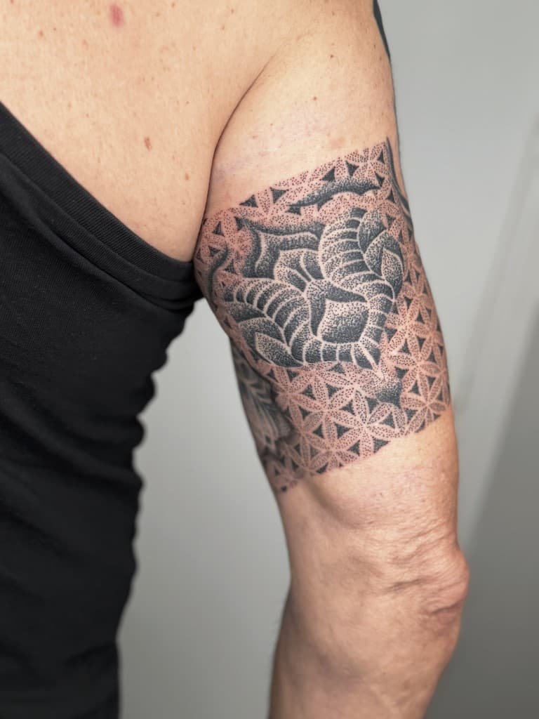 Geometrische dotwork band op bovenarm