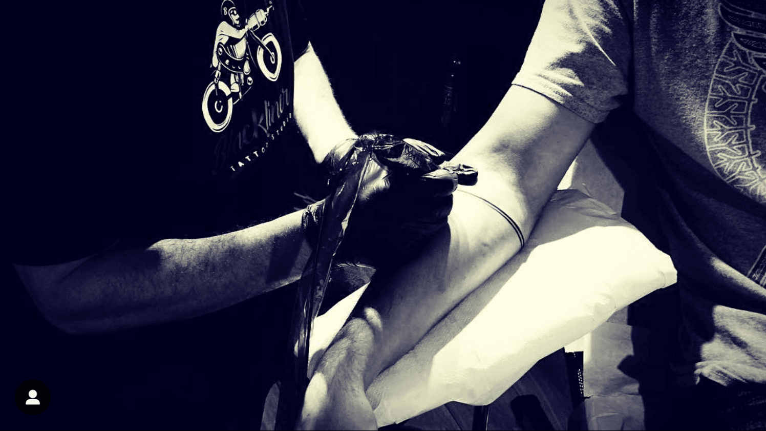 Fineline armband tattoo op onderarm tijdens het zetten.