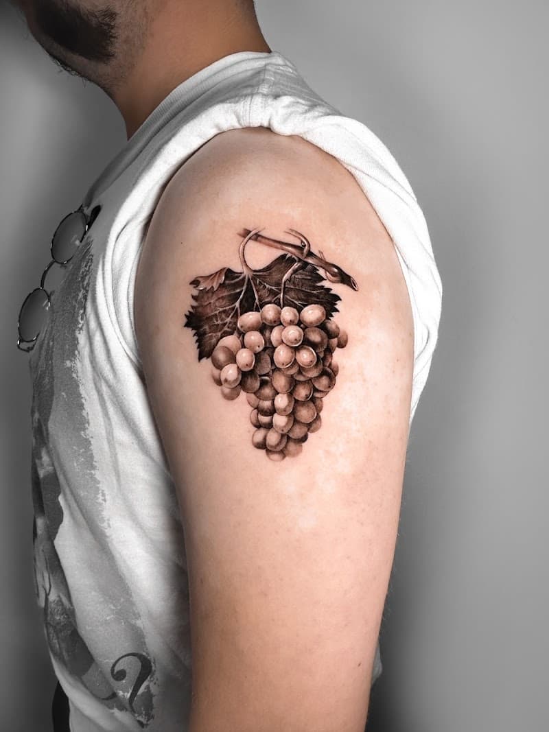 Realistische tros druiven met bladeren op de bovenarm.