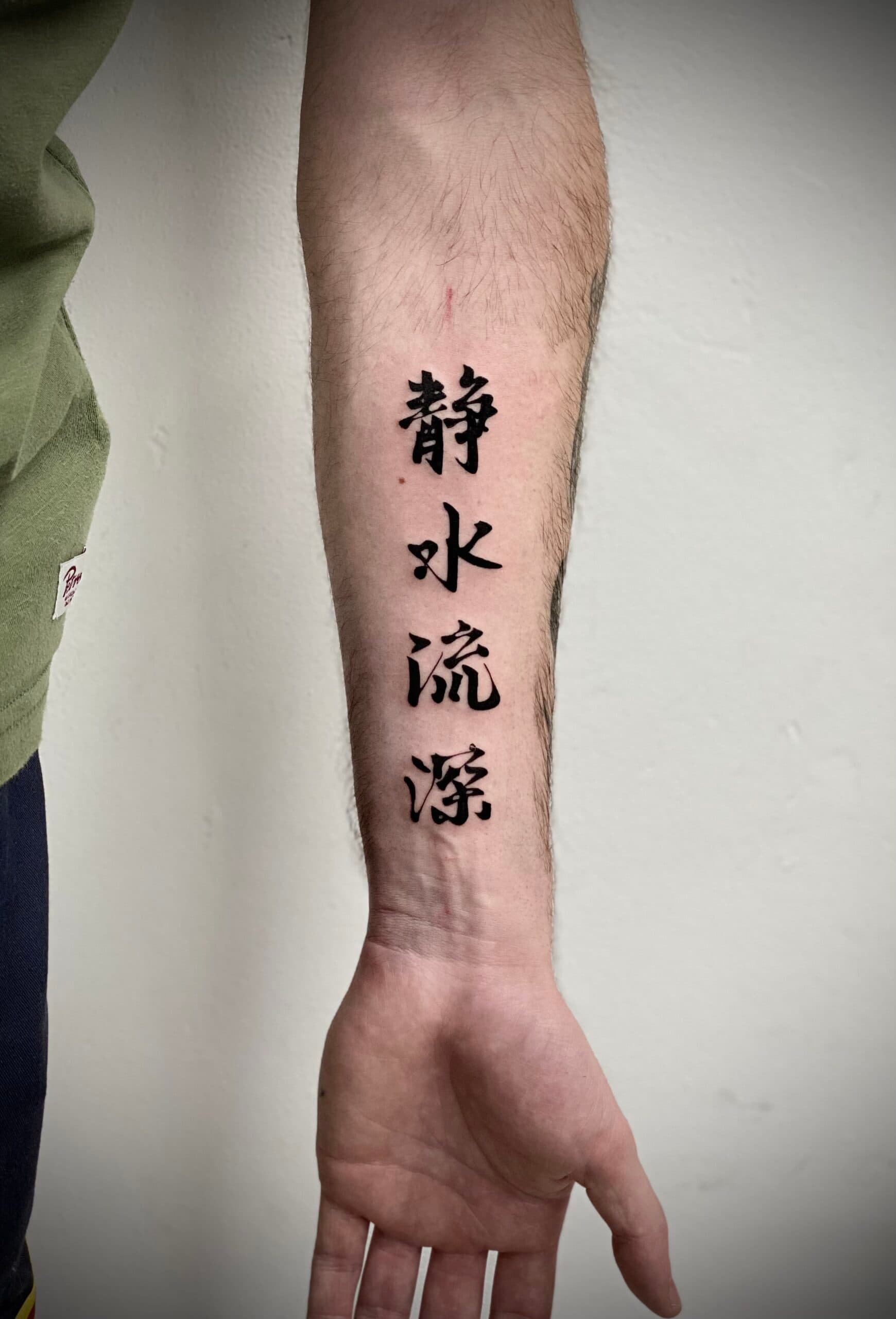Close-up van Chinese karakters op de onderarm.