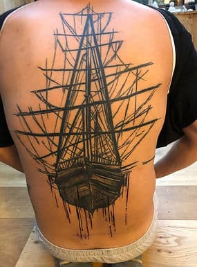 Grote schetsmatige zeilschip tattoo op de rug.