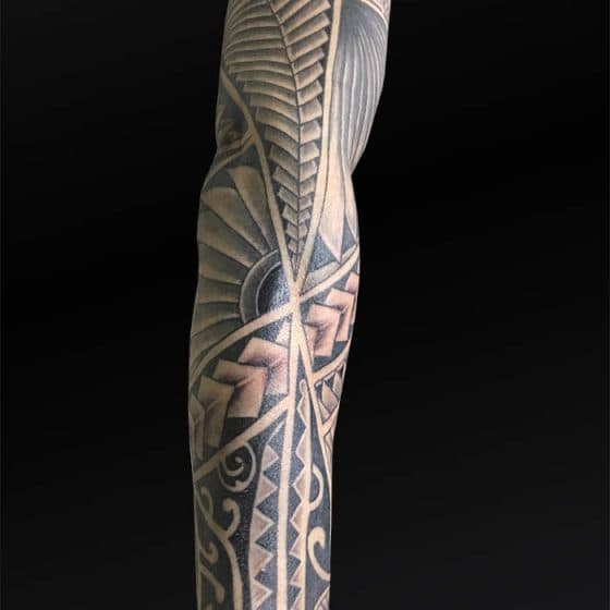 Gedetailleerde Polynesische sleeve tattoo op een arm.