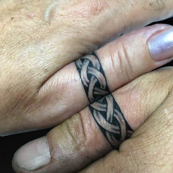 Twee Keltische knoop ring tattoos op duimen.