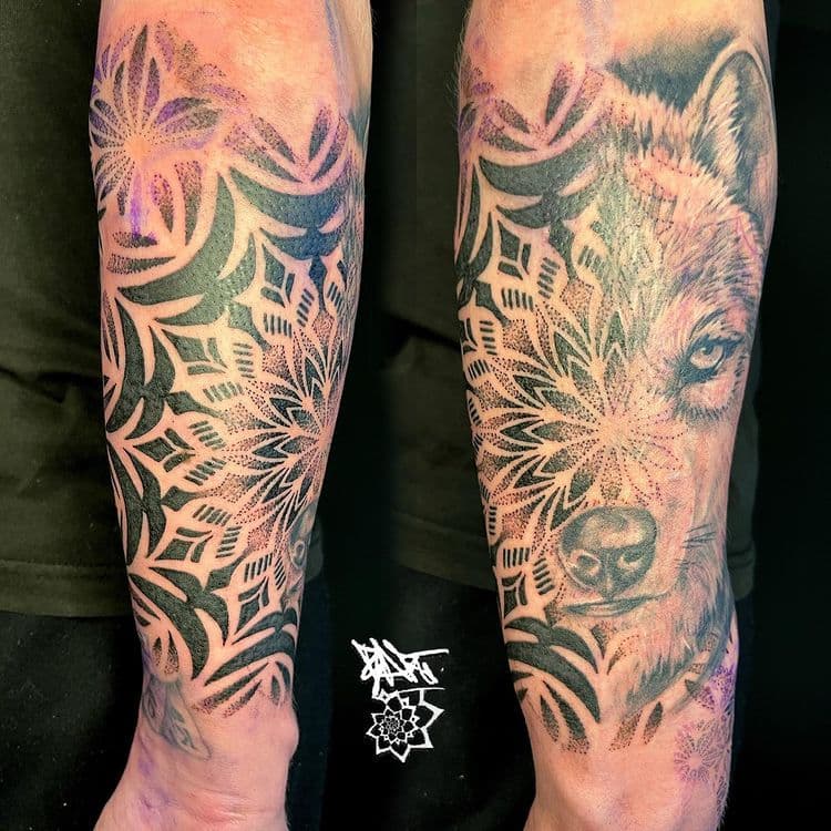 Wolf en mandala tattoo in dotwork en realisme op onderarm.