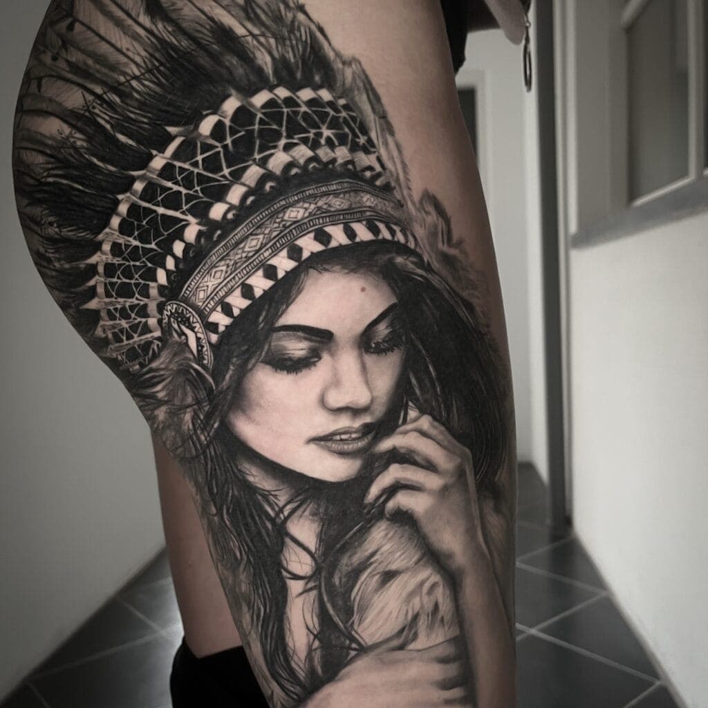 Realistisch portret van een vrouw met een indianentooi op het bovenbeen.