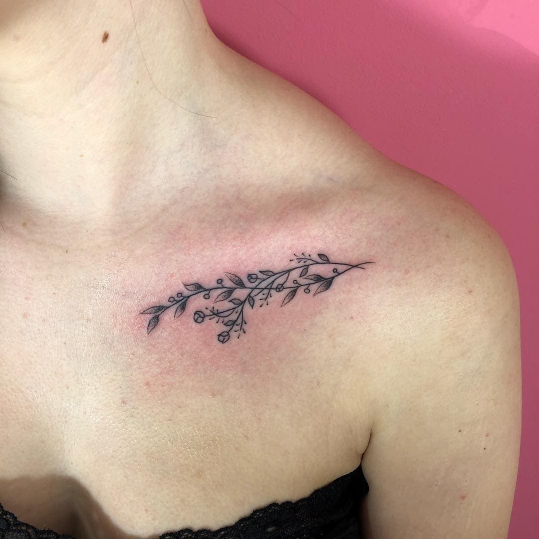 Fineline tak met bladeren en bessen op het sleutelbeen.