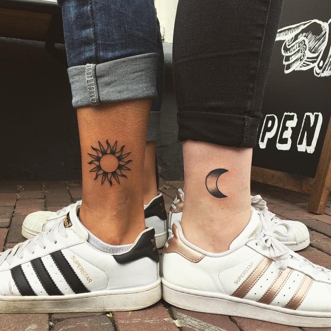 Zon en maan koppel tattoos op enkels in blackwork stijl.