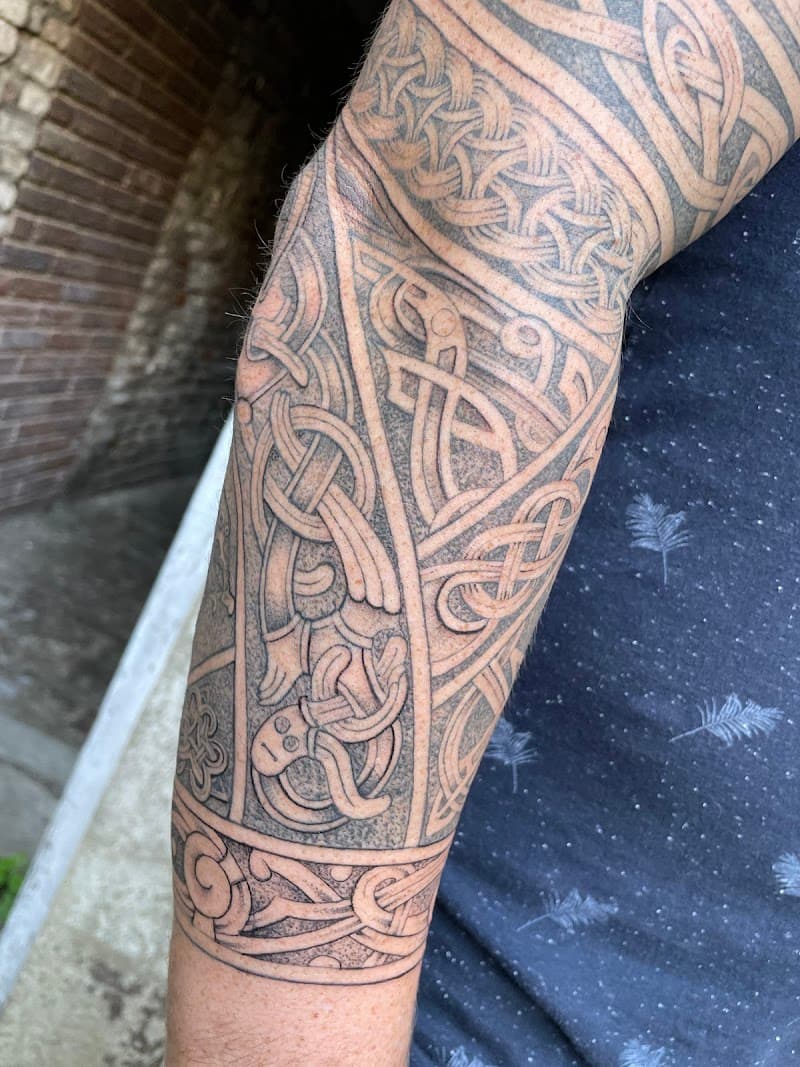 Gedetailleerde Keltische knoopwerk half-sleeve tattoo.