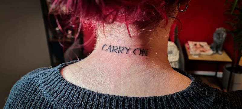 "CARRY ON" tekst tattoo in de nek.
