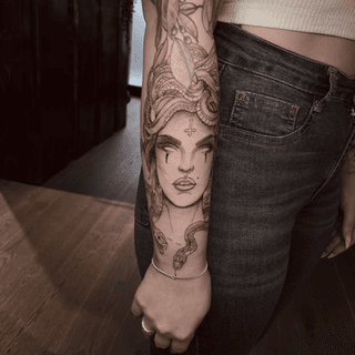 Gedetailleerde Medusa tattoo met slangenhaar op de onderarm.