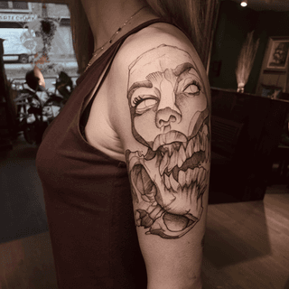 Illustratieve tattoo van een gezicht dat transformeert in een monsterlijke bek.