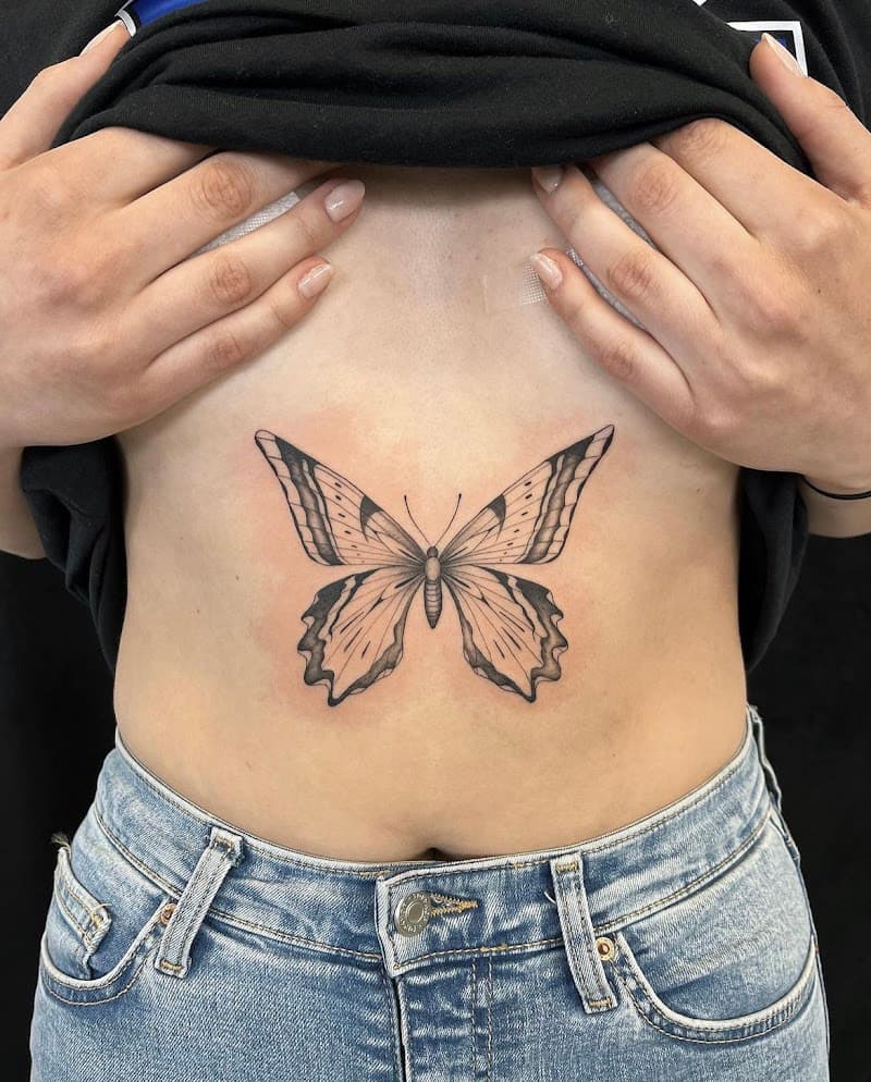 Zwart-wit vlinder tattoo op de buik.