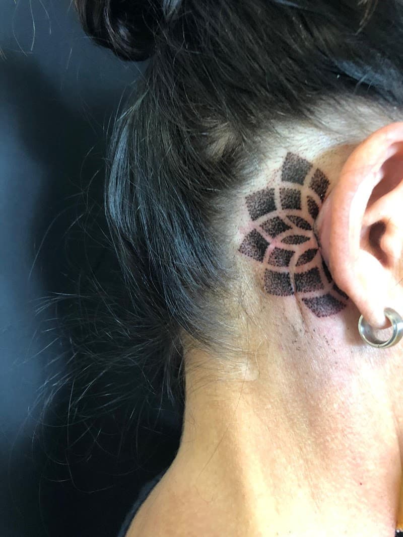 Geometrische dotwork tattoo achter het oor.