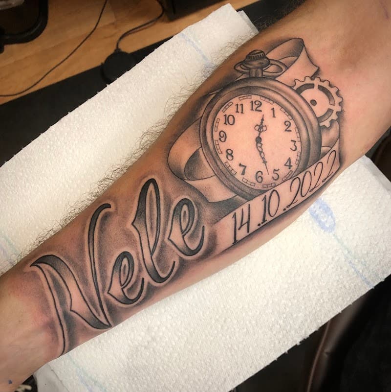 Blackwork tattoo met naam 'Nele', datum '14.10.2022' en een zakhorloge.