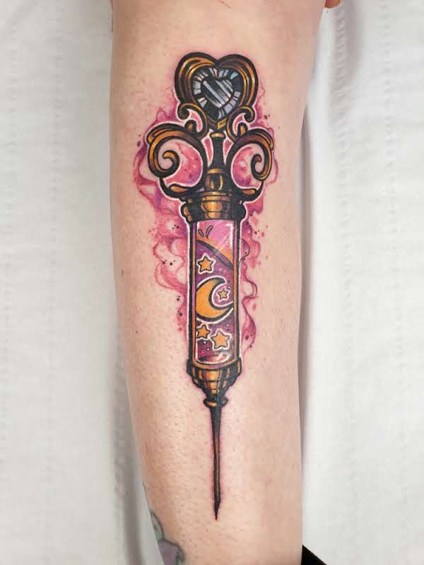 Kleurrijke neo-traditional tattoo van een magische spuit met maan en sterren.